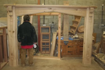 002-large-oak-fireplace-in-workshop-man-standing-next-to-pillar-for-size