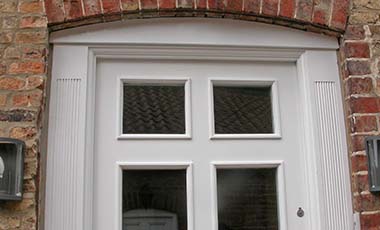 Close up top view of fitted meranti hardwood door with four double glazed windows and side fluted columns