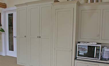 One kitchen cabinet full height with single door and one cabinet double door also full height in cream colour fitted snugly over steps