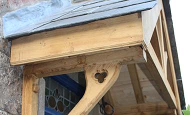Bespoke oak porch angled shot of supporting brackets with decorative carved quatrefoil