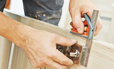 man using set square to fit a door lock