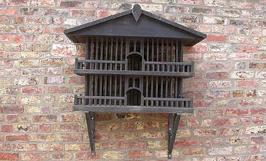 Close up of bespoke bird house. Two-tier design with banister balconies